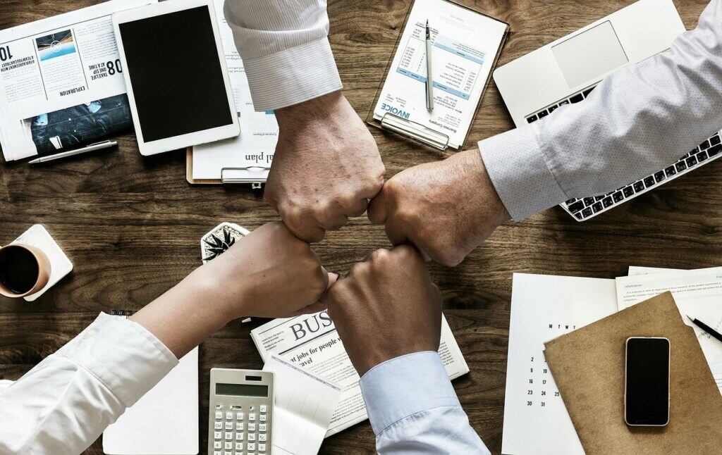 hands meeting in the middle of a table showing teamwork
